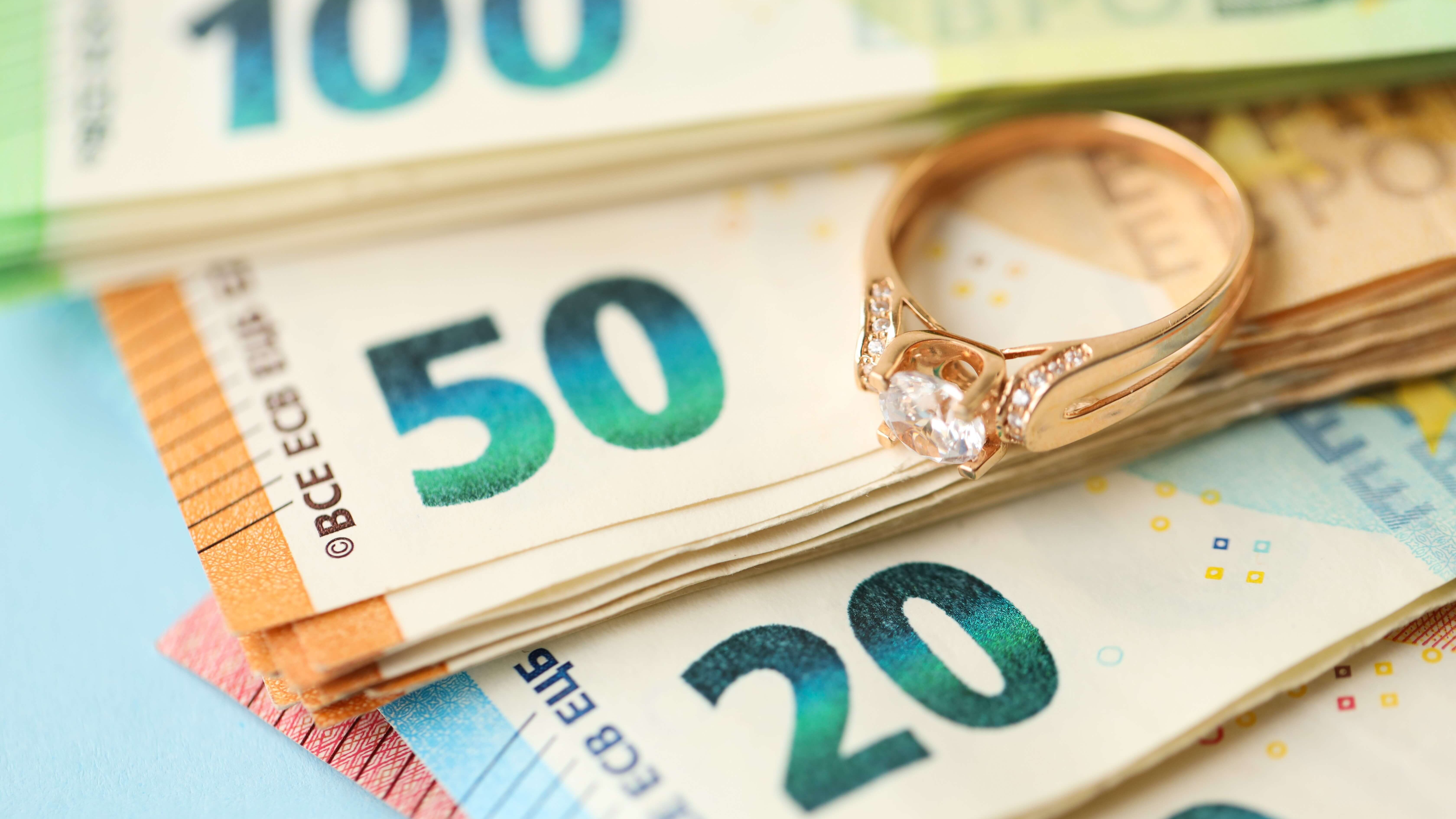 Euroscheine und ein goldener Ring mit Diamant